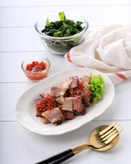 Se'i Sapi or  Beef Sei is Indonesia Traditional Smoked Beef, Served with Boiled Cassava Leaves and Sambal Luat or Sambal Matah. Typically Food from Nusa Tenggara, Indonesia