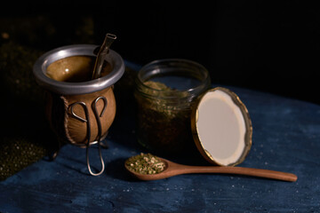 Still life of yerba mate. Glass jar, Calabash and bombilla with yerba mate. Dark food concept.