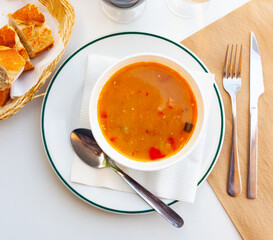 Bowl of traditional spanish dish Lentils a la Riojana - thick spicy stew with lentils, vegetables, sausages and meat