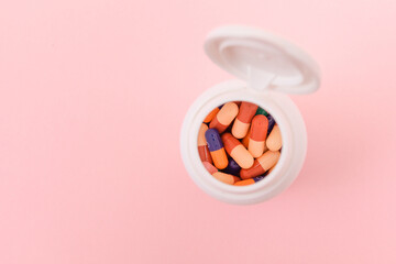 Global Pharmaceutical Industry and Medicinal Products - Different Colored Pills, Tablets and Capsules in Bottle Lying on Pink Background. Copy Space, Top View, Flat Lay