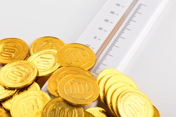 The thermometer is detecting the temperature of the gold coin