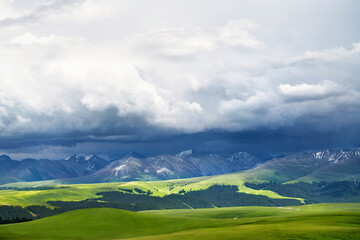 Grassland and mountains in a cloudy day. Photo in Kalajun grassland in Xinjiang, China.
