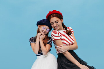 Fashionable charming two sisters with ginger hair and freckles in striped t-shirts, bouffant skirts...