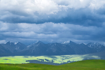 Grassland and mountains in a cloudy day. Photo in Kalajun grassland in Xinjiang, China.