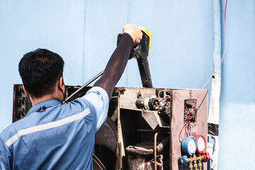 Bangkok Thailand - June 23, 2021. Asian man is using a high-pressure cleaner to skillfully exhaust the air compressor.