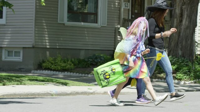 Kids out on halloween with their mom trick or treating girls