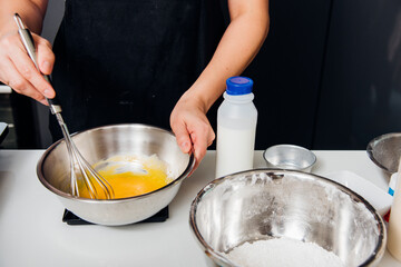 Woman beat dough mixer manual by hands in bowl at her kitchen
