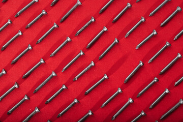 Black steel nails, arranged horizontally, leaving a space in the shape of a rhombus or horizontal...