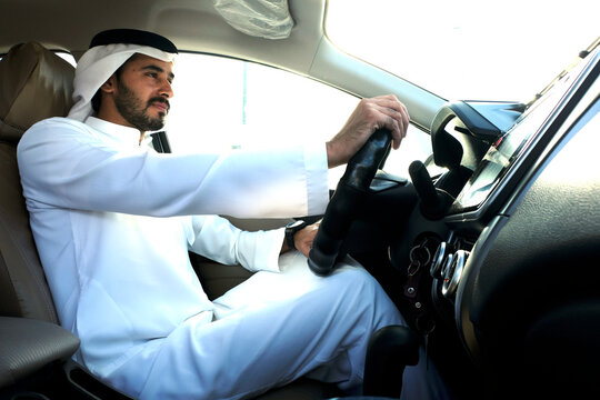 Driving Arab wearing Kandura Dish dash. Emirati man inside a car