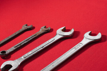 Wrenches, rusty, arranged in ascending order on a red background leaving space for advertising text. Construction tools
