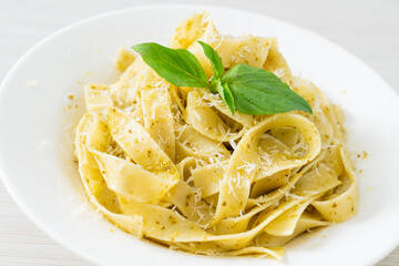 pesto fettuccine pasta with parmesan cheese on top