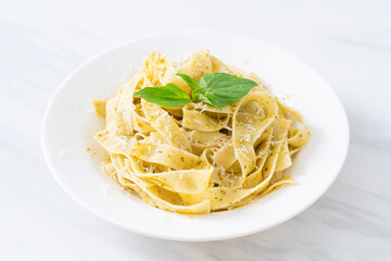 pesto fettuccine pasta with parmesan cheese on top