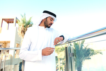 Arab corporate man standing wearing traditional UAE menswear garment. Arabic national in Dubai.