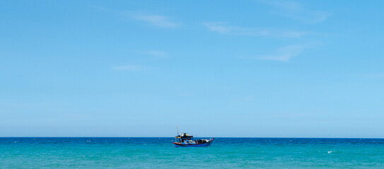 Fishing boat staying still in the big blue ocean and sky