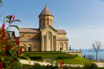 Picturesque sunny spring landscape with Church of Saint Nino in Georgian Orthodox monastic complex at Bodbe near Sighnaghi town