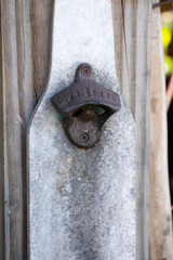 rustic and rusty antique bottle opener in the shape of a bottle in the backyard bar with vintage flair
