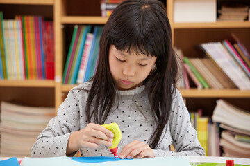 夏休みの家で工作の宿題をしている小学生の子供の様子