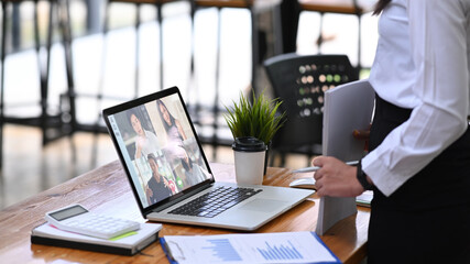 Businesswoman having video conference with diverse colleagues on laptop computer.
