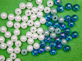 Beads spread on green background. Background or texture of beads. Close up.