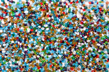 colorful beads scattered on a white background, beads for beadwork, beads for needlework, close-up