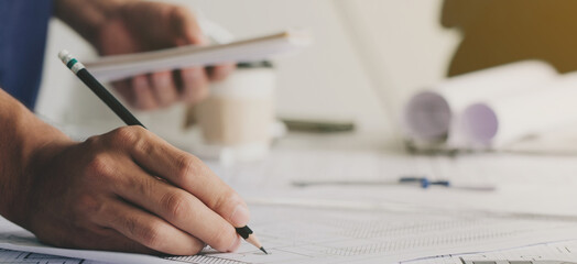 Close-up Of Engineer Hand Drawing Plan On Blue Print with architect equipment, working with partner and engineering tools on the workplace. Engineering tools and construction concept.