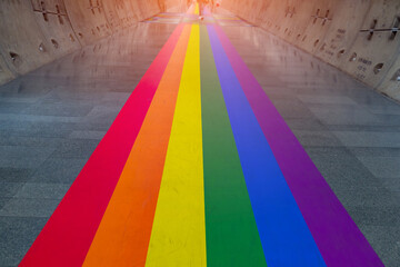 Gay pride rainbow colors or  LGBT colors is in underground tunnel.Transport walkway by Tunnel Boring Machine for infrastructure subway with raw concrete segments wall.Light at the end of the tunnel. - Powered by Adobe