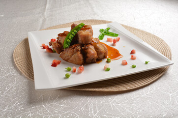 Stir fried dark plum sweet and coffee sauce pork spare ribs meat with almond in white background asian banquet menu