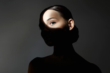 portrait of young woman with light on her face - obrazy, fototapety, plakaty