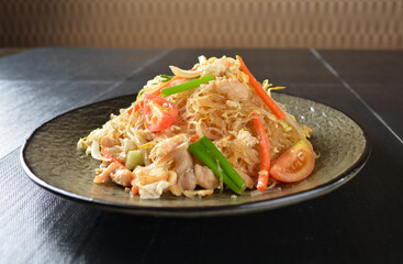 stir fried vermicelli rice noodle with vegetables and meat in black background asian banquet menu