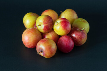 Fototapeta na wymiar Closeup of A pile of fresh cherry plums on a dark surface.