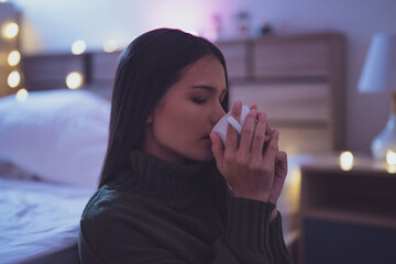 Asian woman drinking tea at night, she is feeling relaxed.