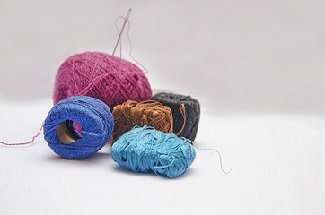 skeins of thread with a needle on a white background, skeins of thread close-up