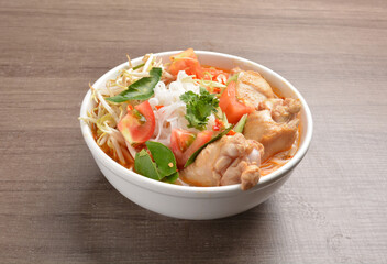 braised cook chicken drumstick meat with red spicy curry soup and vermicelli noodle in wood background asian halal menu