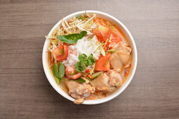 braised cook chicken drumstick meat with red spicy curry soup and vermicelli noodle in wood background asian halal menu