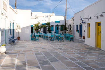 Serifos island, Chora, Cyclades Greece. Open empty cafe tavern chairs tables background.