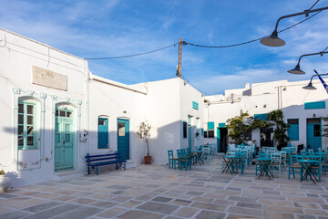 Serifos island, Chora, Cyclades Greece. Open empty cafe tavern chairs tables background.