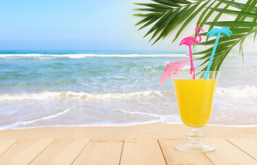 image of tropical and exotic fruit coctail over wooden table infront of sea landscape background