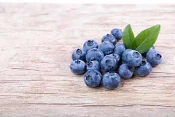 blueberries with green leaves  on wooden background 