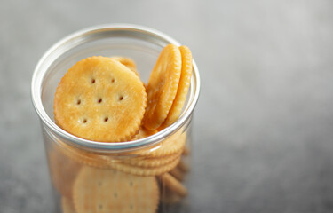 An image selected focus circle crackers or snack or biscuits in plastic cans treat gourmet or junk food falling and cracking on the ground with copy space for text.