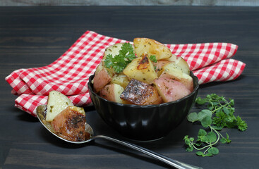 A black bowl of grill roasted red potatoes.