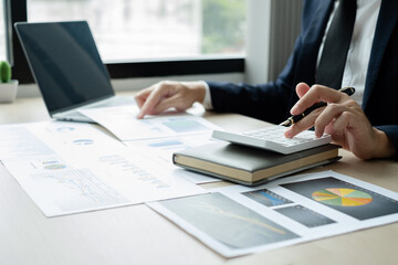 The hand of businessman sit at their desks and calculate financial graphs showing results about their investments, plan a successful business growth process