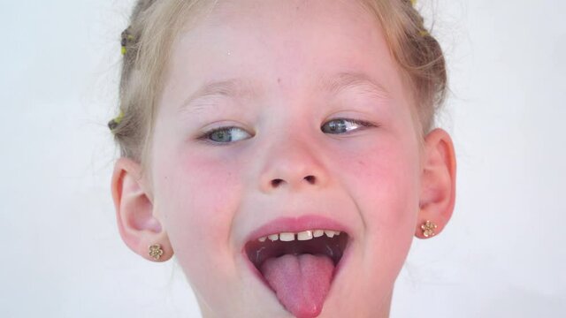 little girl show tongue, throat and smile. Happy baby on white background. portrait with wide open mouth and protruding tongue. with clear view pulls out long tongue. soft palate and mouth