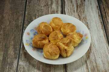 Pile of Choux cream serving on the plate. Classic sweet dessert in party or ceremony.