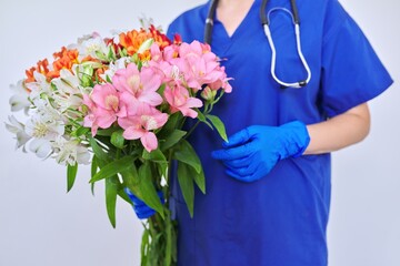 Health day, close-up bouquet of flowers in the hands of doctor nurse