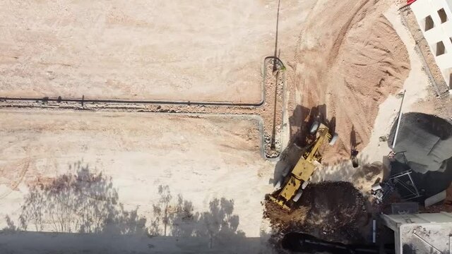 toma de un tractor con dron excavando un terreno para un proyecto de apartamentos