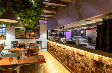 Interior of cozy restaurant in the modern style with open kitchen