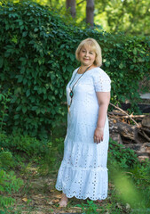 Fototapeta premium Portrait of attractive plus size mature woman in casual style walk at good sunny day. Life of women after 40-50 years