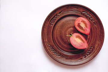 Tomato sample. Fresh tomatoes on a beautiful clay plate on a white background. Flat lay, top view, copy space
