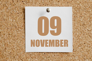november 09. 09th day of the month, calendar date.White calendar sheet attached to brown cork...