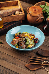 Blue plate of grilled veal meat with vegetables